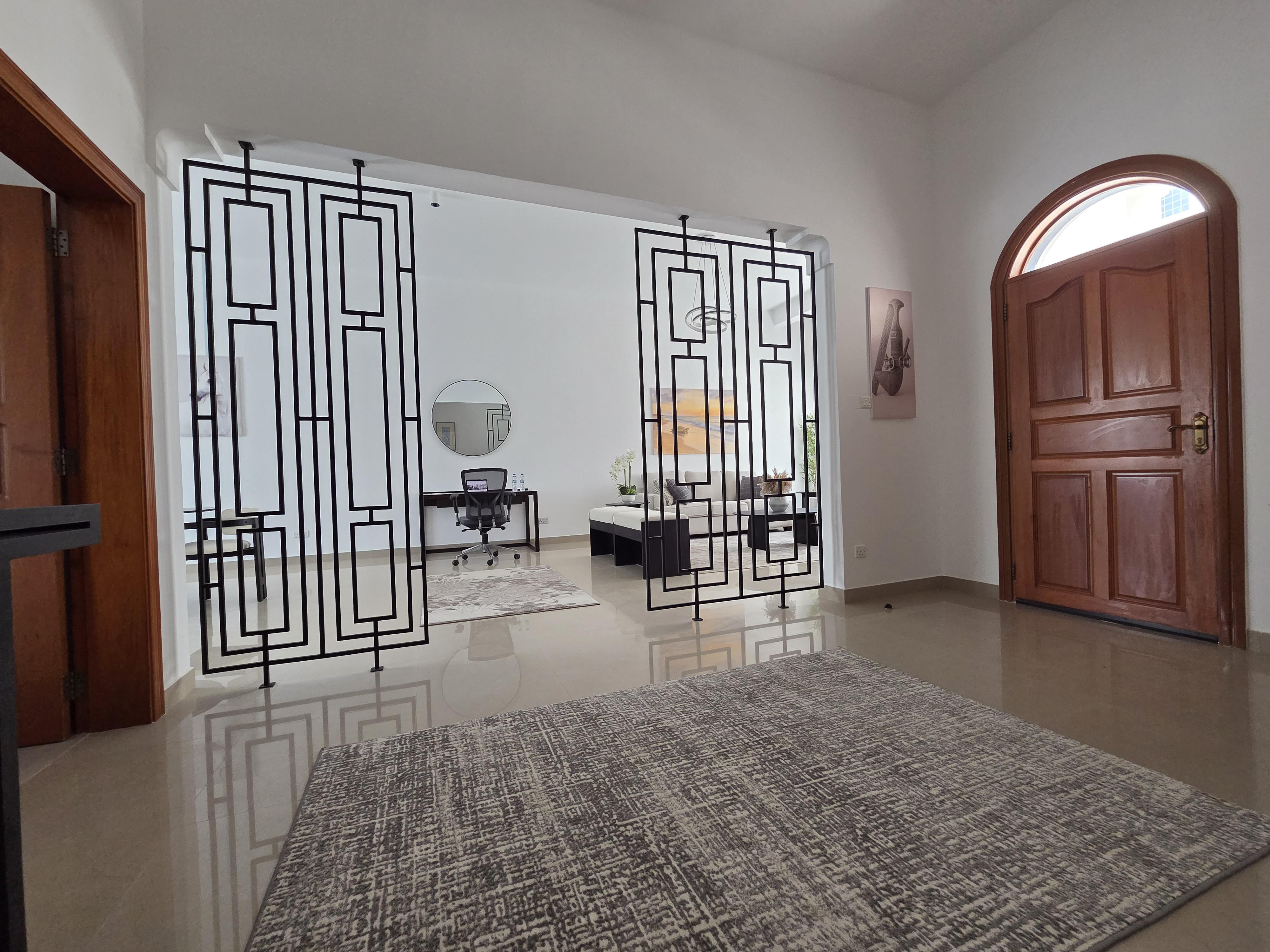 Front desk area with a dark wood counter, backlit shelving and eclectic decor.